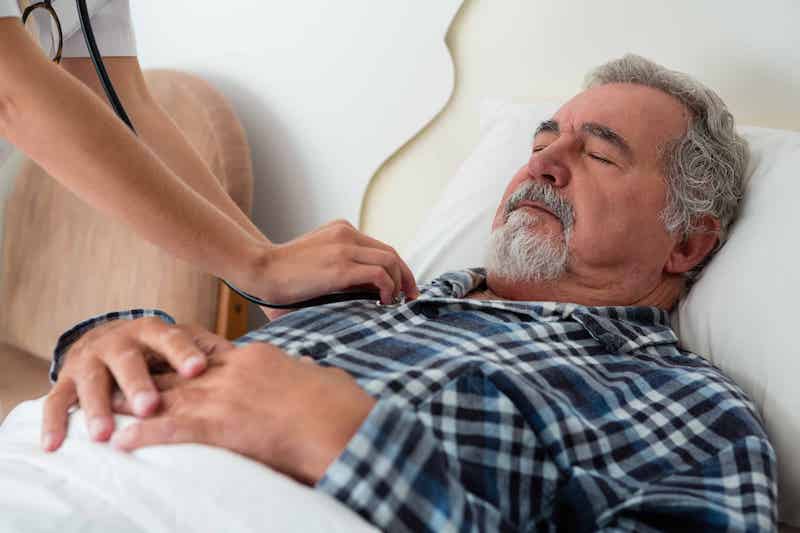 Doctors hands checking heart rate of sleeping man